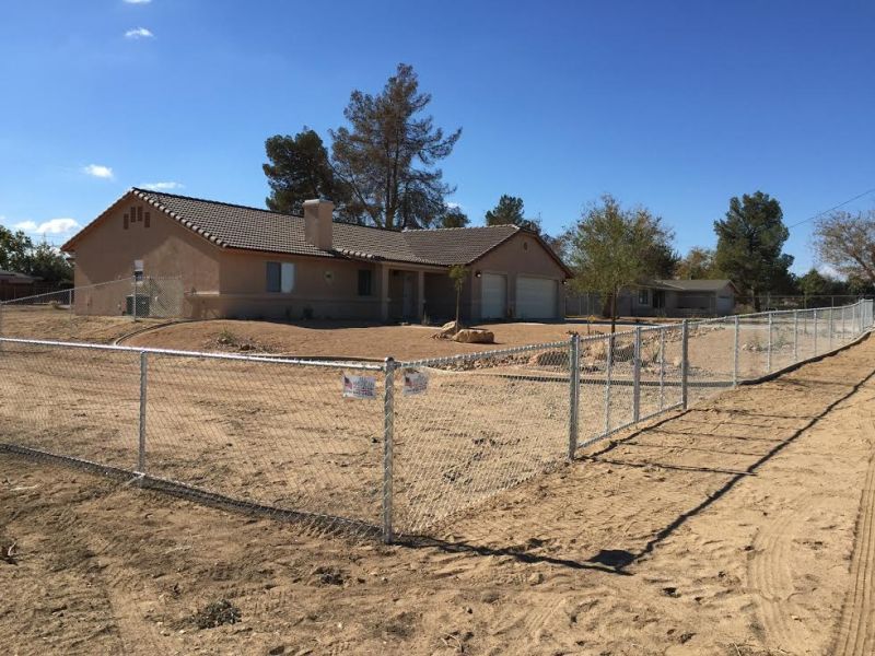 Home surrounded by chain link fence