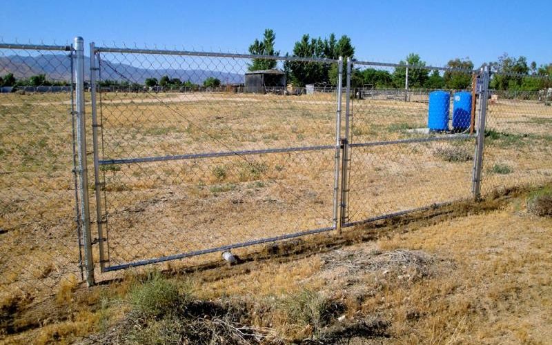 A chain-link fence with a double swing gate.