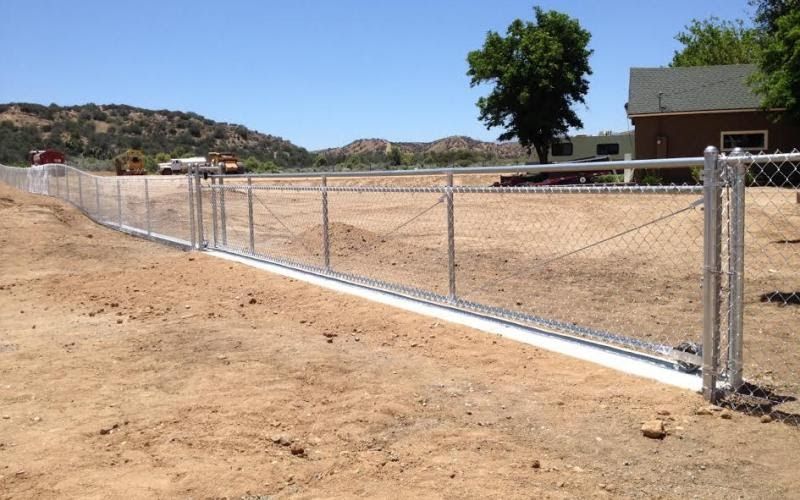 Pinch roller gate with chain link fence.